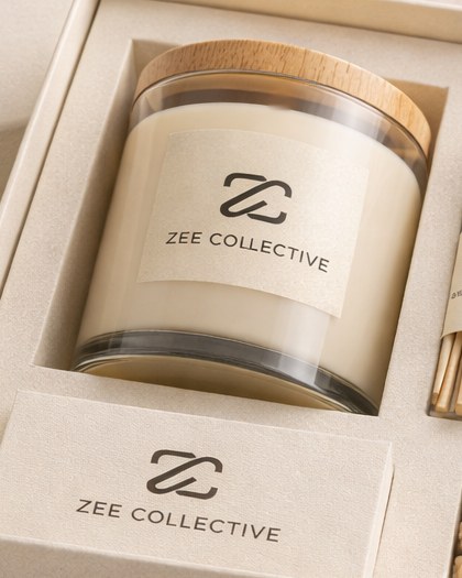 A Zee Collective soy candle in the ivory gift box, freshly lit