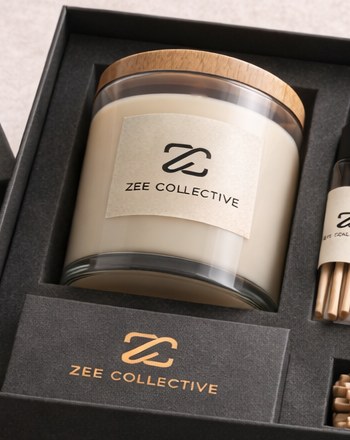 A Zee Collective soy candle with a wooden lid in the black gift box